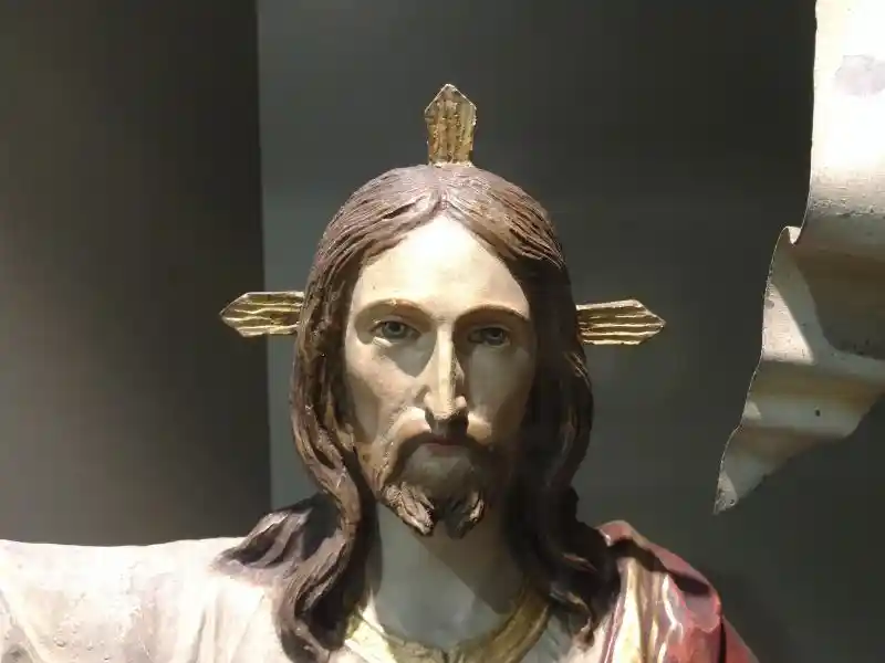 Statue of Jesus with three-point rays on the head holding victory flag